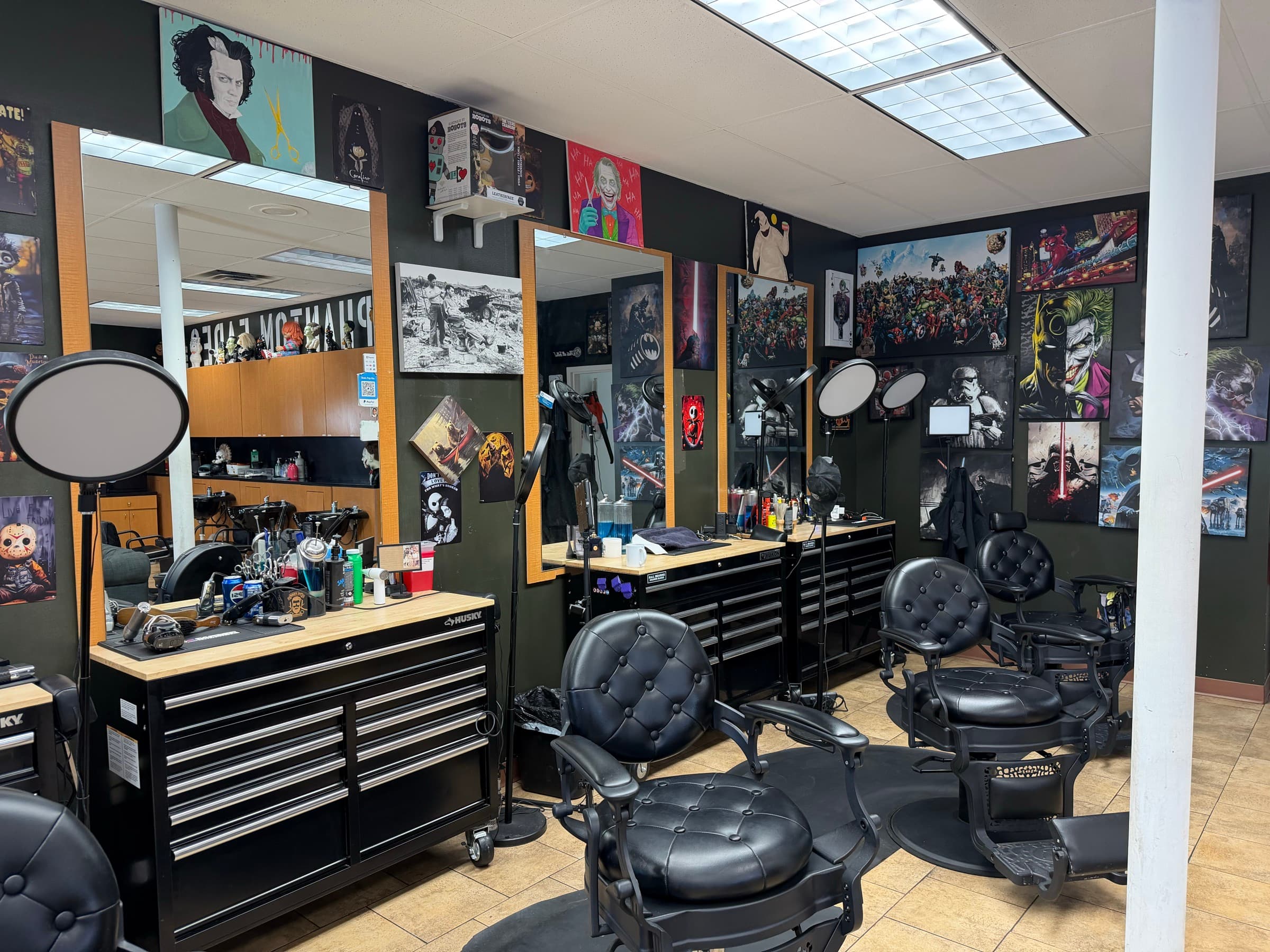 Phantom Fades cutting floor in Burnsville — black tufted leather chairs, ring-light stations, and pop-culture posters lining the walls.