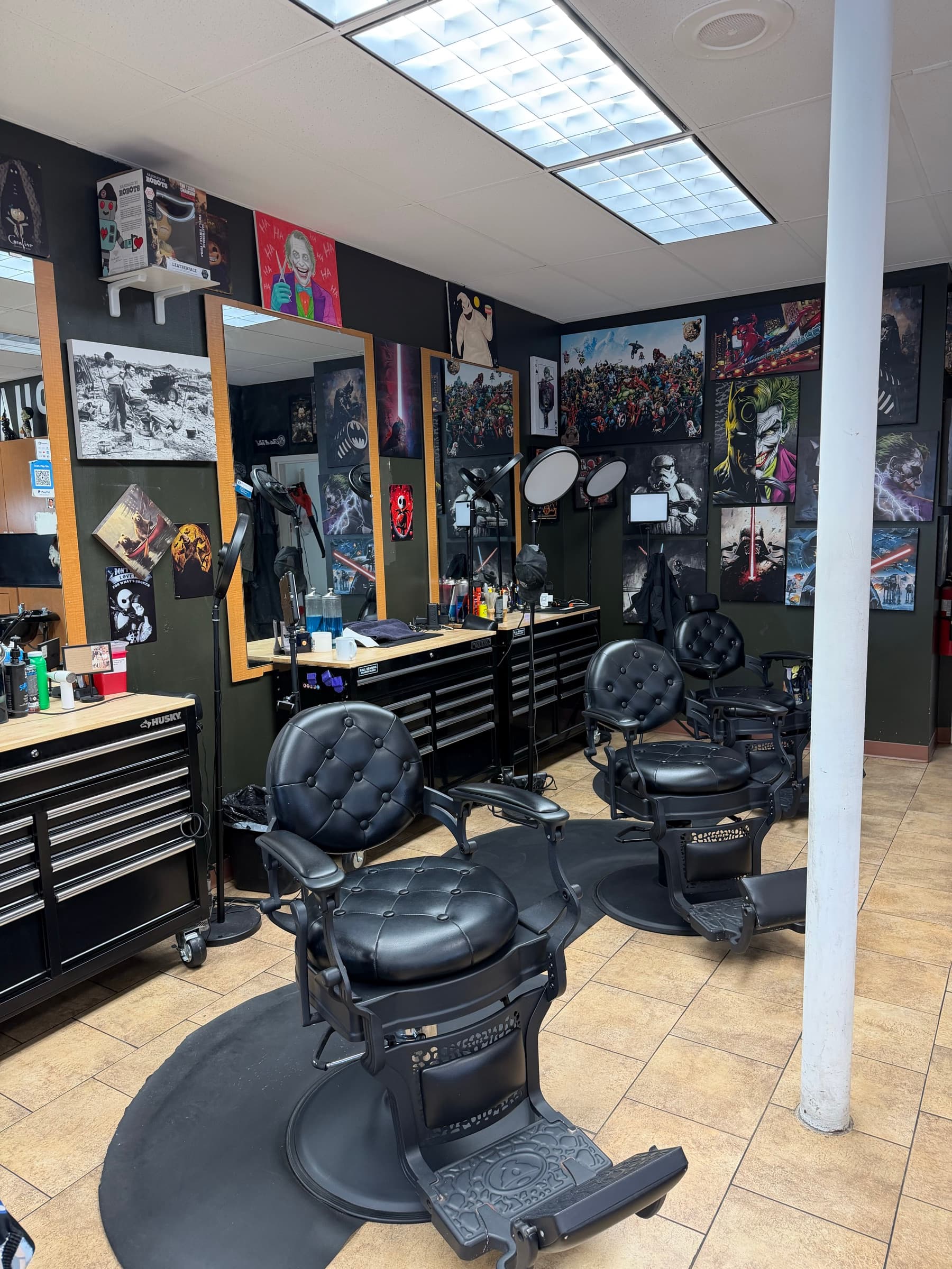 Phantom Fades cutting station with horror movie posters covering the walls and antique tufted chairs