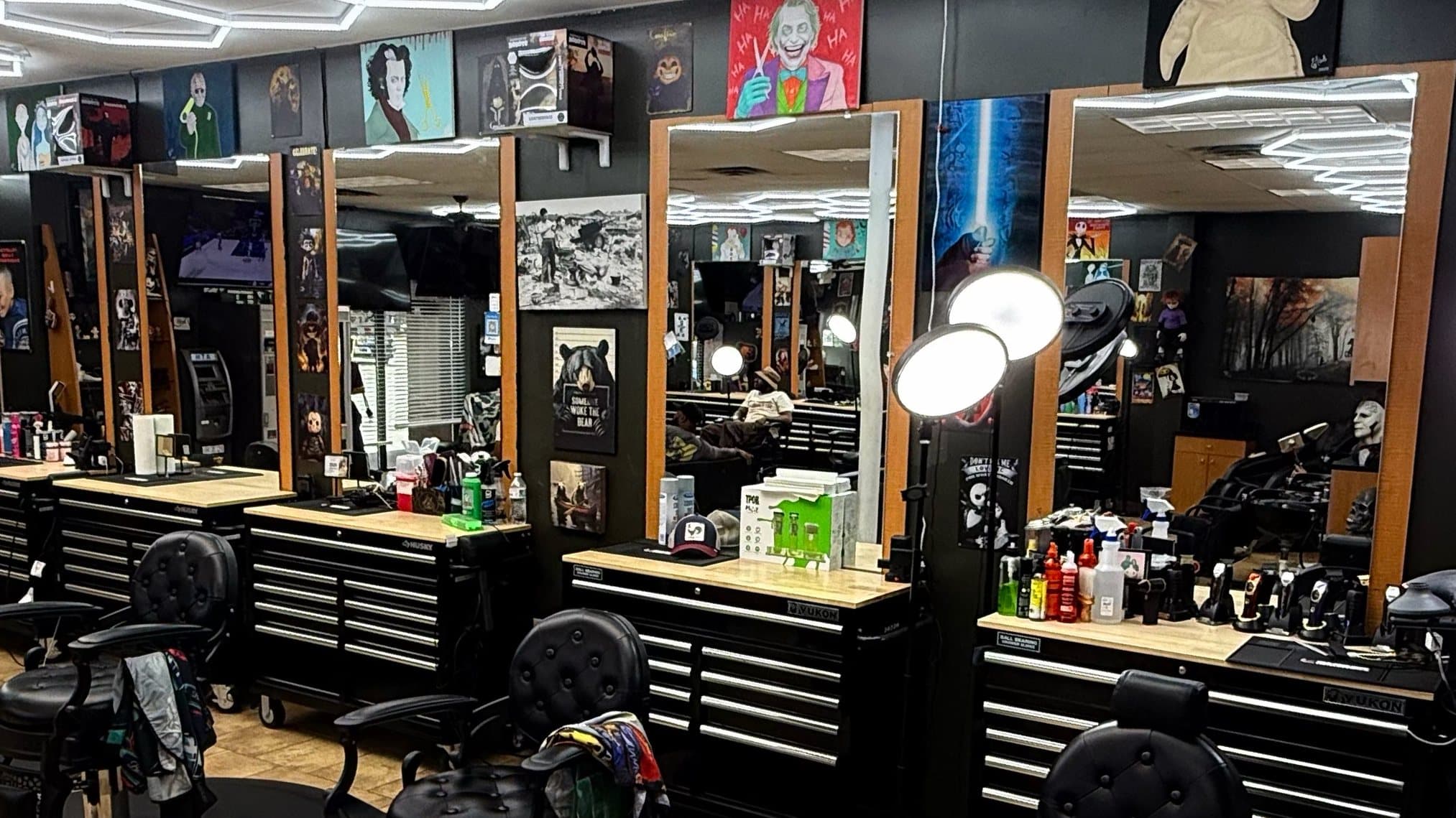 Phantom Fades stations with black tufted barber chairs and ring lights under the hexagon LED ceiling